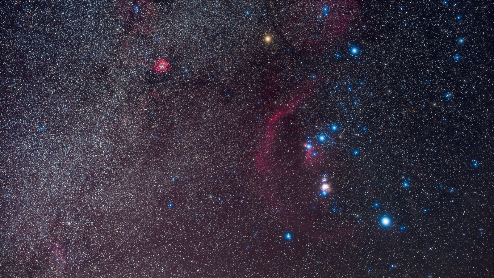 Stars shine bright in the Orion nebula's streaks of red and blue in the night sky