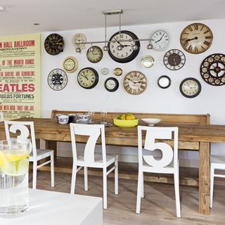 dining area with wall clocks and dining table and wooden floor and white chair