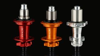 Hope Pro 5 hubs in orange red and silver against a black background