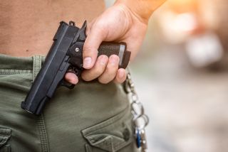 person holding gun hidden