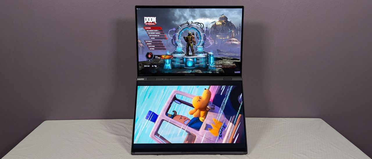 A view of a laptop with two screens from the front, propped up on top of a flat surface covered with a white cloth.