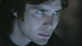 An intense Cillian Murphy looks up from a lit table in Sunshine.