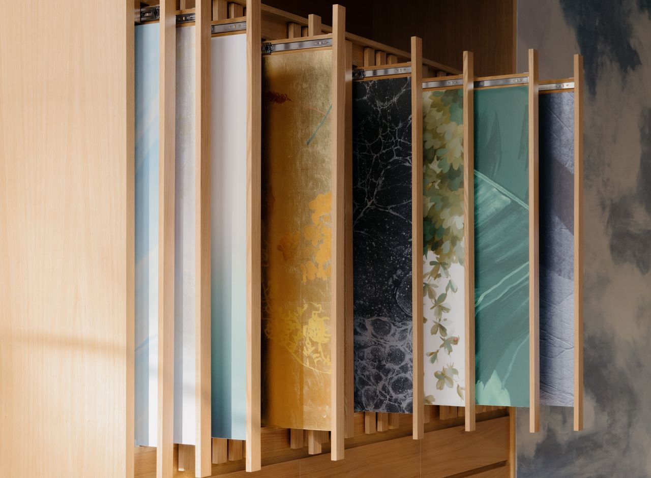 A cabinet full of different wallpapers by Calico Wallpaper