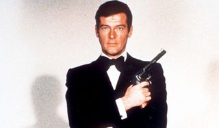 Roger Moore, posing in a tuxedo with a revolver