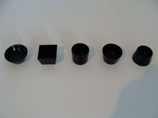 Five black sake cups in different shapes photgraphed on a white surface
