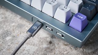 A photo of the Keychron Q1 Pro in gray aluminum with white, black and purple keycaps.