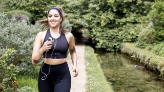 Running outside vs treadmill: Image shows woman jogging in rural area