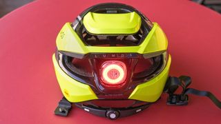 Lumos Ultra Fly Pro bike helmet in neon yellow against a red background