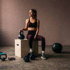 Functional fitness workouts: A woman stretching in a gym with weights