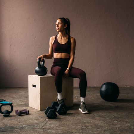 Functional fitness workouts: A woman stretching in a gym with weights