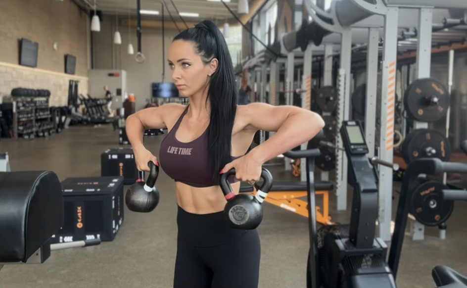 Woman exercises with kettlebells in gym