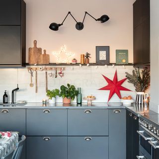 Kitchen with navy cabinets and white worktops decorated with Christmas decorations