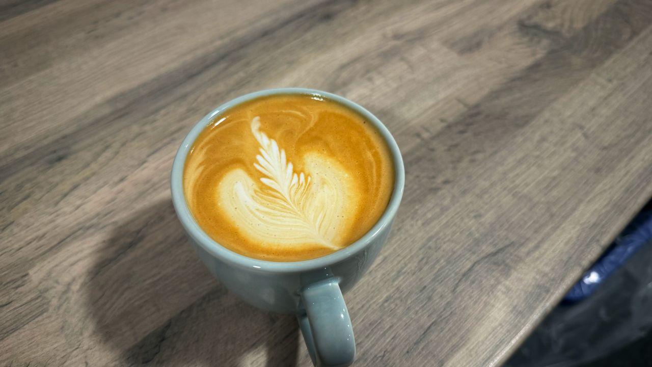 the smeg EMC02 Mini Pro manual espresso machine in action, extracting espresso and steaming milk