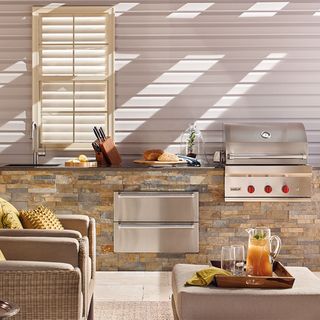 outdoor kitchen with arm chair and kitchen appliances