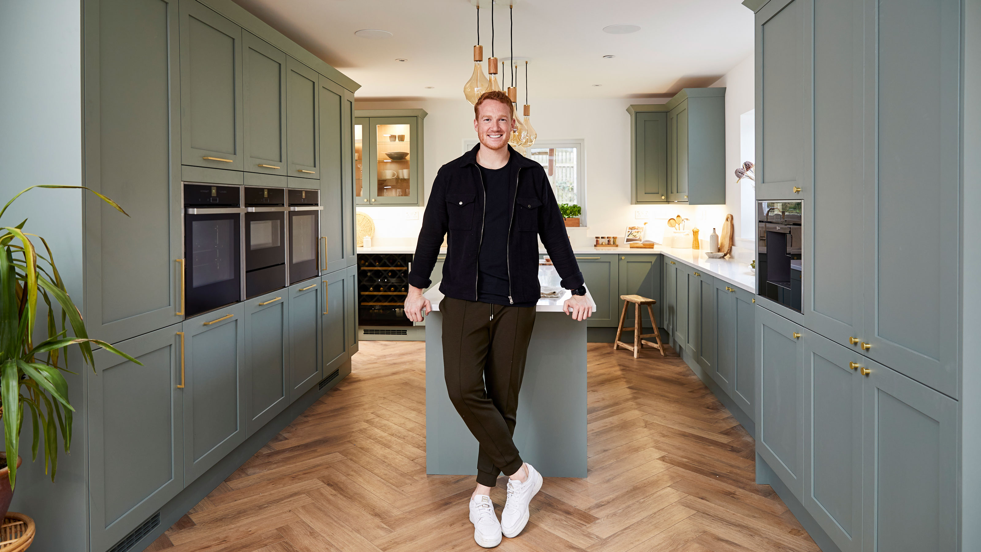 Greg Rutherford's kitchen with green cabinetry and a kitchen island