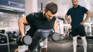 Man performs incline dumbbell row