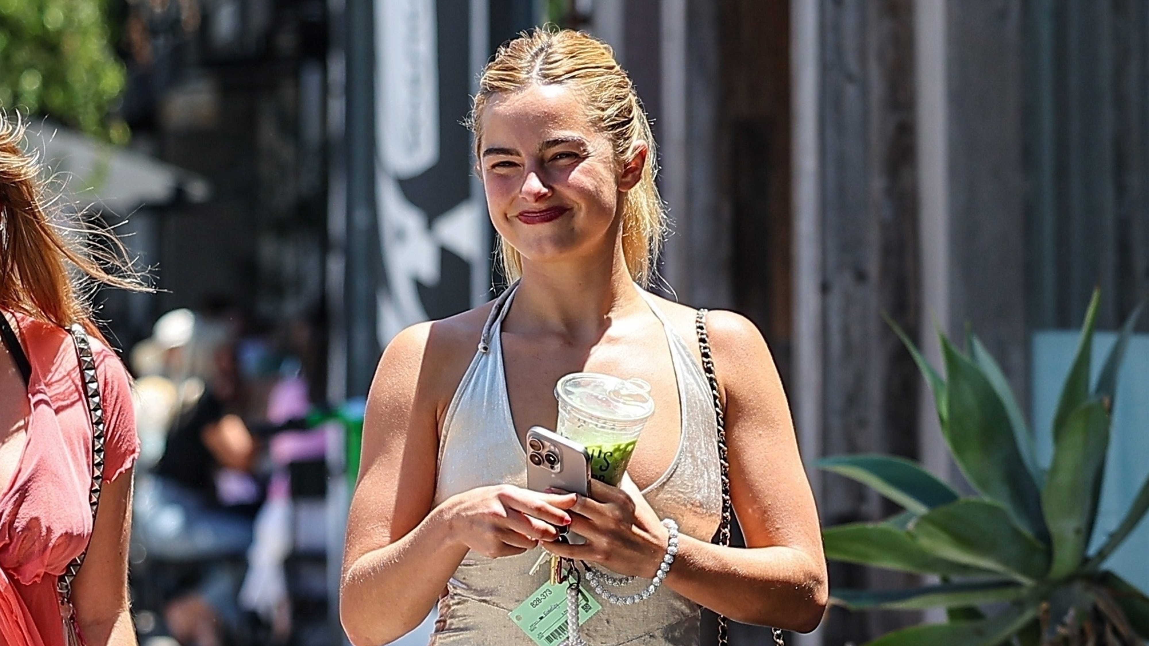 Addison Rae walking with a matcha latte in hand.