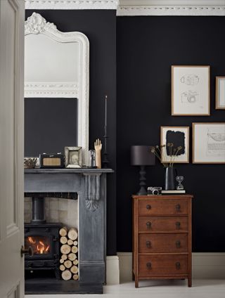 Dark living room with large mirror and grey Victorian fireplace