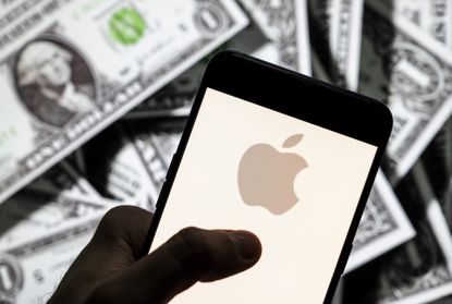A picture of an iPhone and an Apple logo on the screen with dollar bills in the background