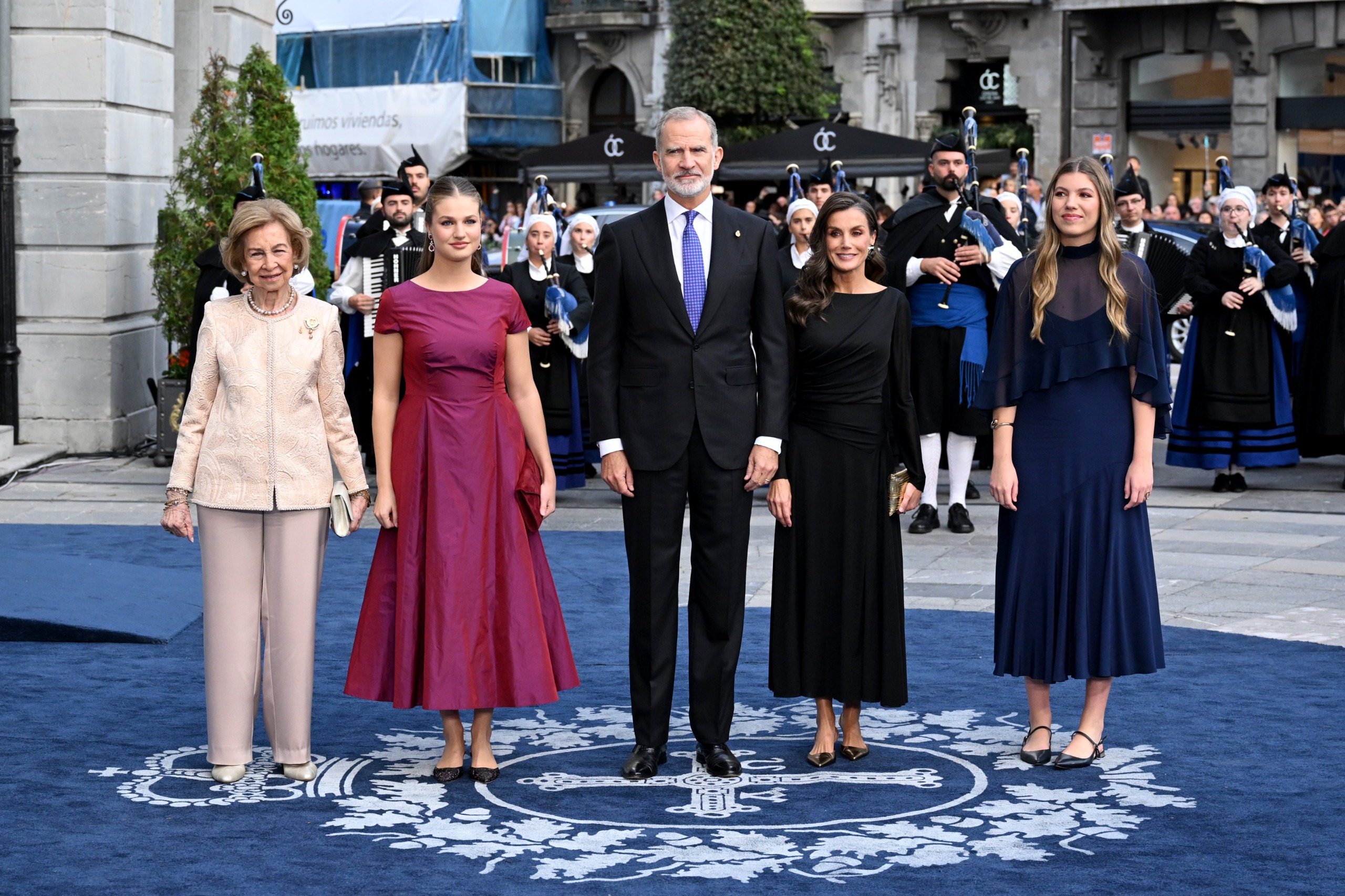 Queen Sofia, Princess Leonor, King Felipe, Queen Letizia and Princess Sofia standing on a blue carpet at the Princess of Asturias Awards