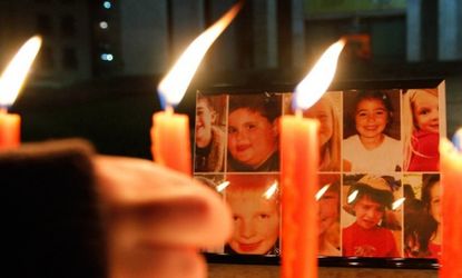 A boy pays his respects to the victims of the Sandy Hook Elementary shootings during a candlelight vigil in Tirana, Albania.