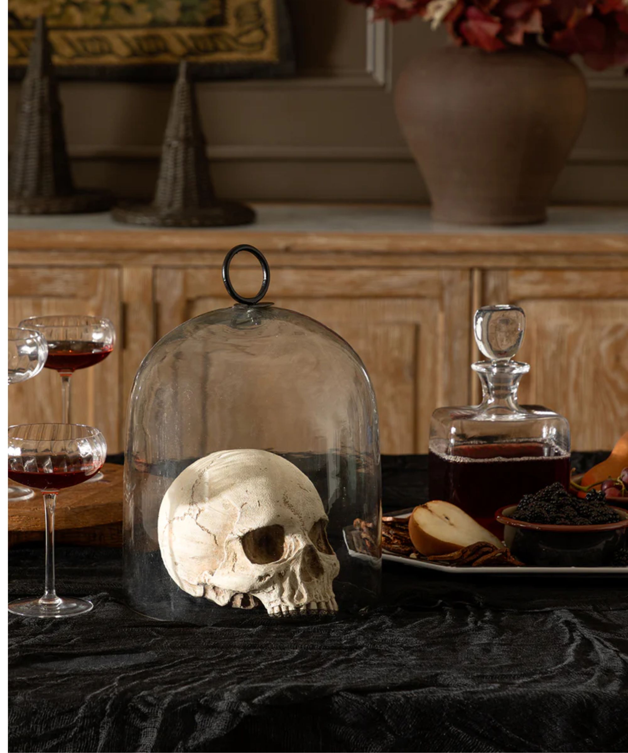 Glass cloche with skull ornament inside