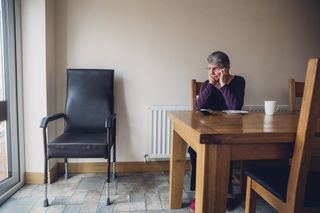 Senior Woman Sitting Beside an Empty Chair