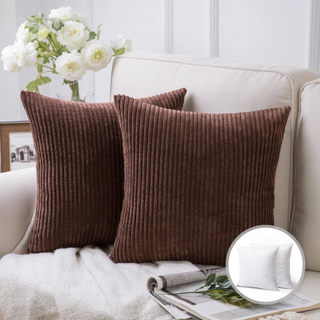 Two brown throw pillows sitting on a sofa