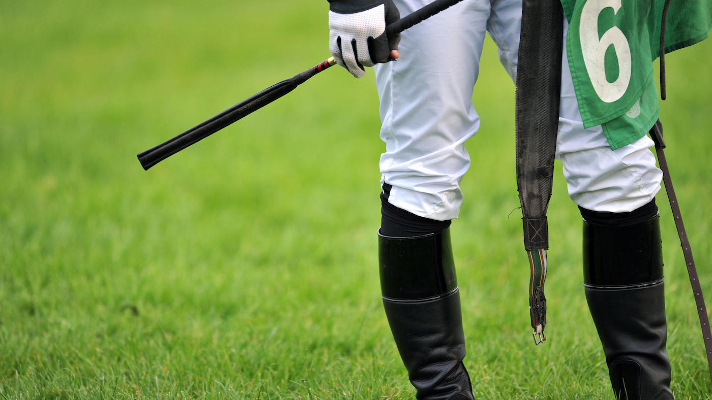 Racing whip rules: image shows an unidentifiable jockey holding a whip