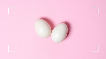 Two whole white eggs on light pink background to represent what to eat if you have a vitamin B12 deficiency
