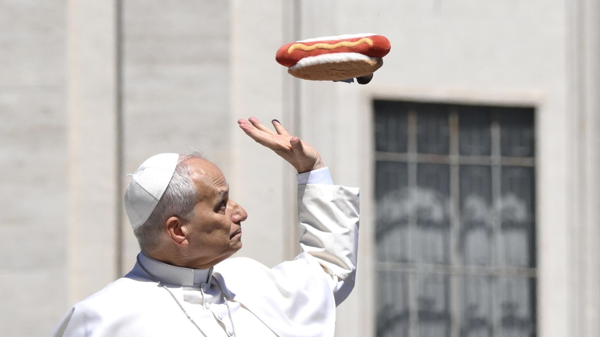 
                                Pope Leo XIV tries to catch a stuffed toy in the shape of a hot dog that a faithful threw at him at the end of the general audience in St. Peter's Square, Vatican City
                            