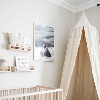 neutral nursery with cot, artwork and ikea spice racks used as shelves