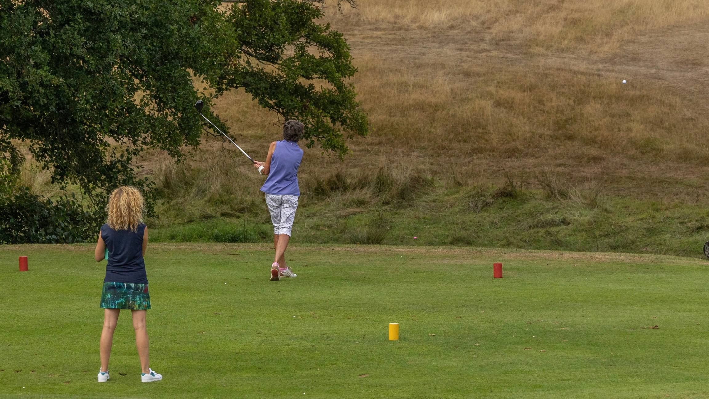 Female golfer teeing off
