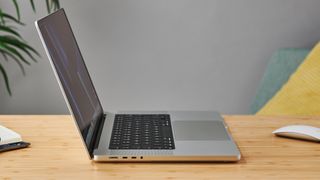 MacBook Pro 16 tum på ett träbord i ett modernt kontor