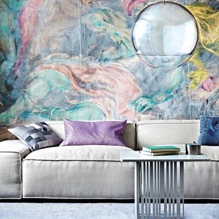 living room with mural wallpaper and sofa with cushions
