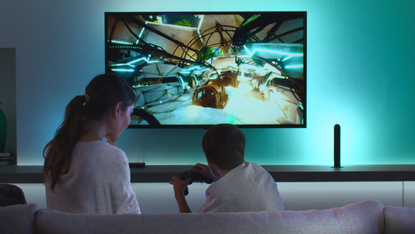 Philips Hue Play HDMI Sync Box being used by child playing a videogame on PS5