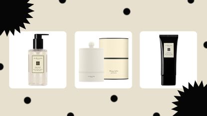three of the products in the Jo Malone Black Friday sales—Jo Malone London Wood Sage & Sea Salt Body & Hand Wash 250ml, Jo Malone London Glowing Embers Scented Candle and Jo Malone London Vitamin E Hand Treatment 100ml—on a beige background with black festive decoration