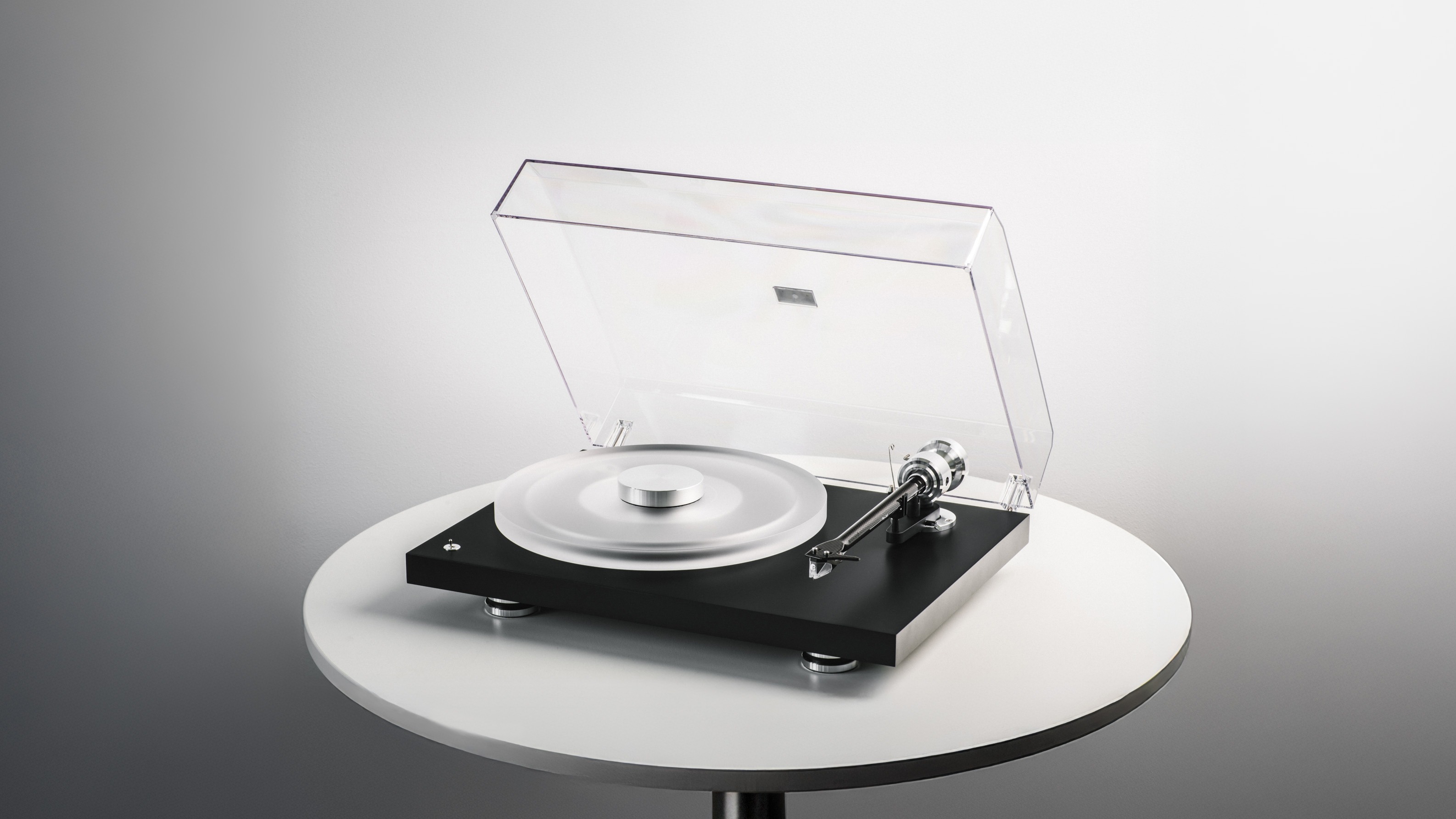 Pro-Ject Debut Reference 10 turntable sitting on a round table