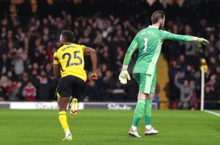 Watford’s Emmanuel Dennis (left) celebrates scoring their side’s fourth goal of the game as Manchester United goalkeeper David de Gea looks frustrated during the Premier League match at Vicarage Road, Watford. Picture date: Saturday November 20, 2021