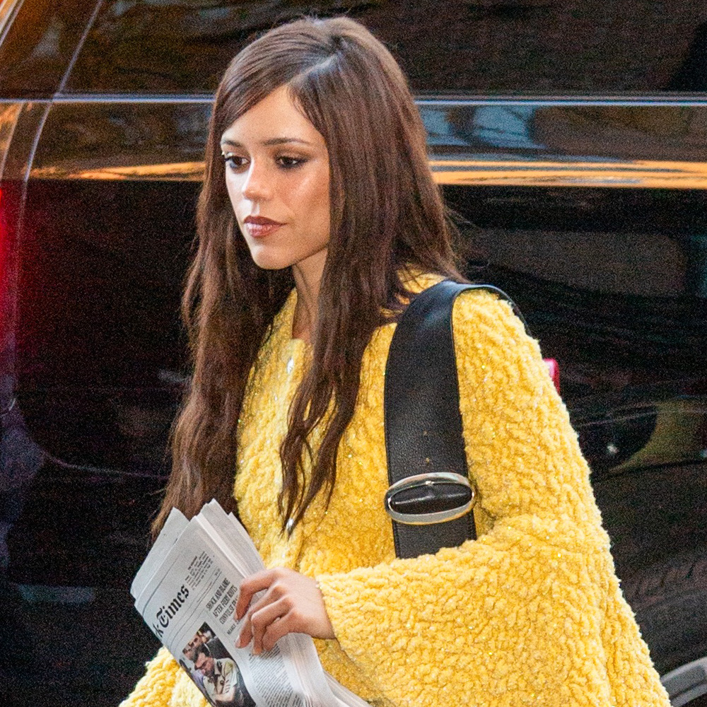 Jenna Ortega wearing jeans, a yellow sweater, and matching yellow pumps