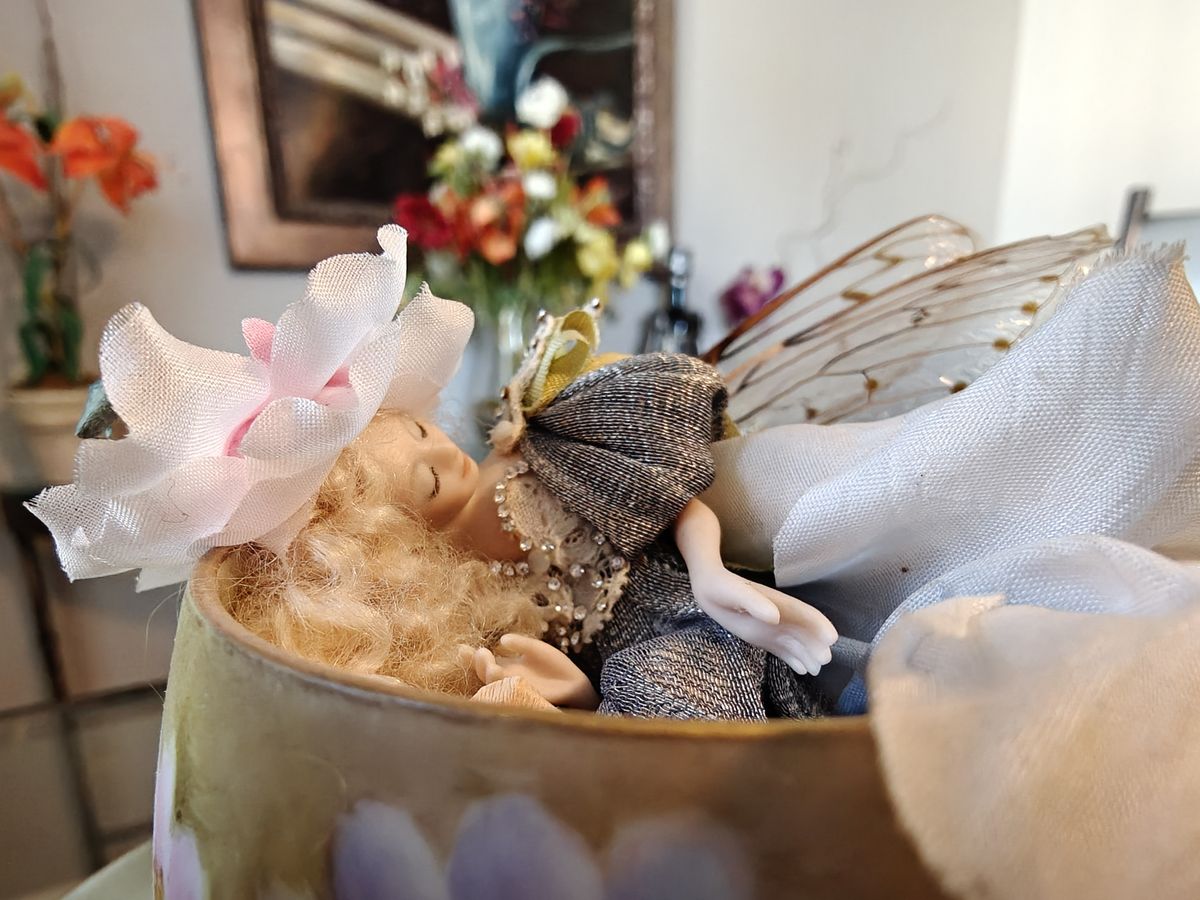 Foto de cerca de un hada de porcelana durmiendo en una taza de t&eacute;