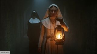 A nun holding a lamp - still from The Nun