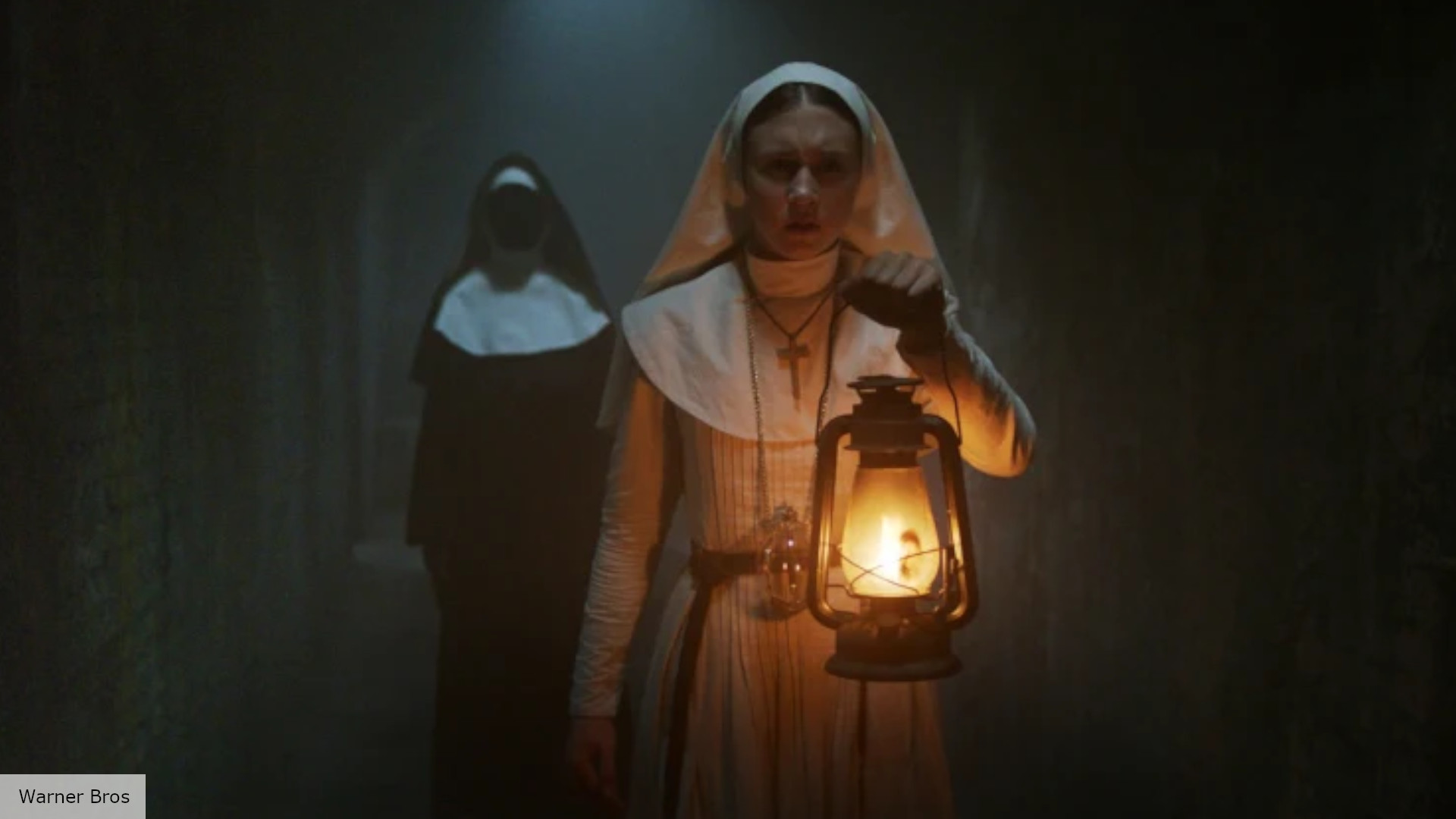 Seorang biarawati memegang lampu - masih dari The Nun
