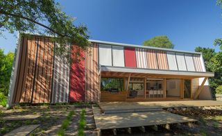 Wooden house with striped red and white blinds on glass panels