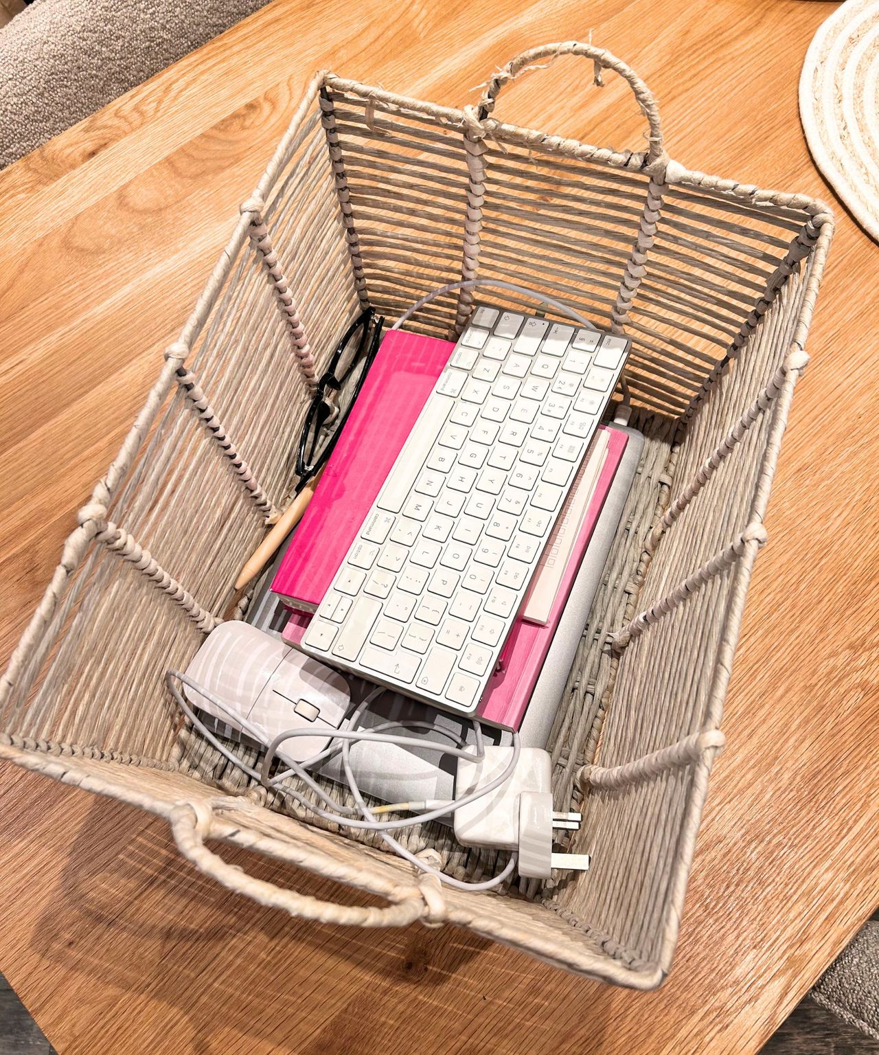 After using the visual clues trick: wooden table with grey storage basket with laptop, mouse, wires and pink diary in it