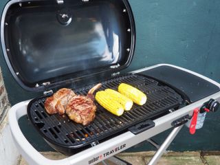 Weber Traveler portable barbecue review, cooking a large steak and corn on the cob on the barbecue