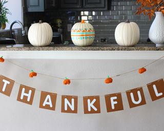 DIY Thanksgiving decor banner idea in kitchen with painted pumpkins