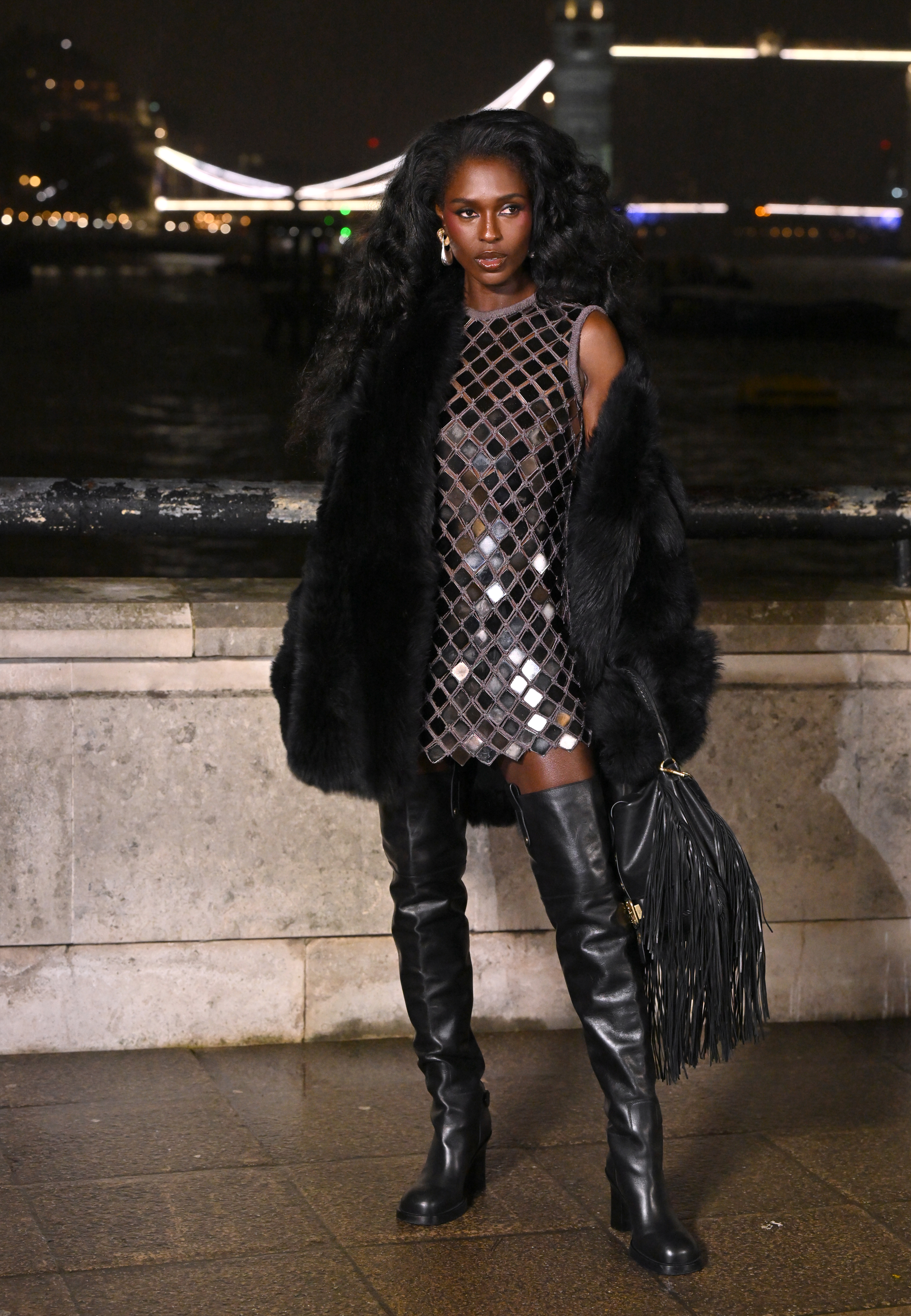Jodie Turner-Smith attended the Burberry Fall 2026 runway show in a disco mini dress, over-the-knee leather boots, a fur coat, and fringe bag