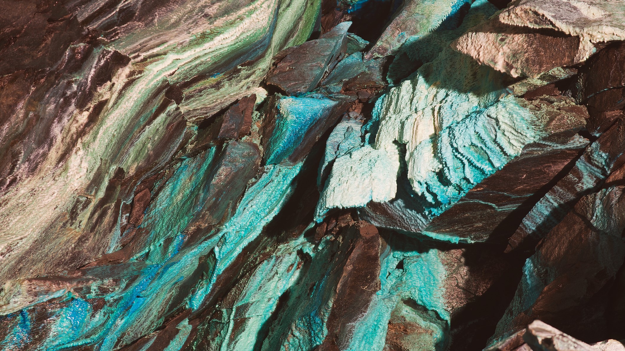 The roof of a copper mine shows blue and green streaks where copper has oxidized.