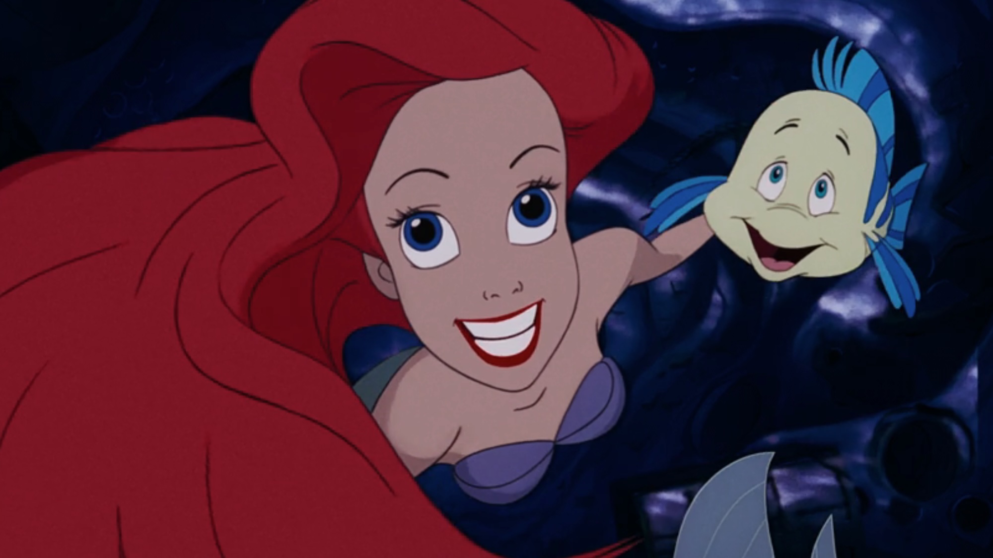Ariel and Sebastian smiling upward in The Little Mermaid